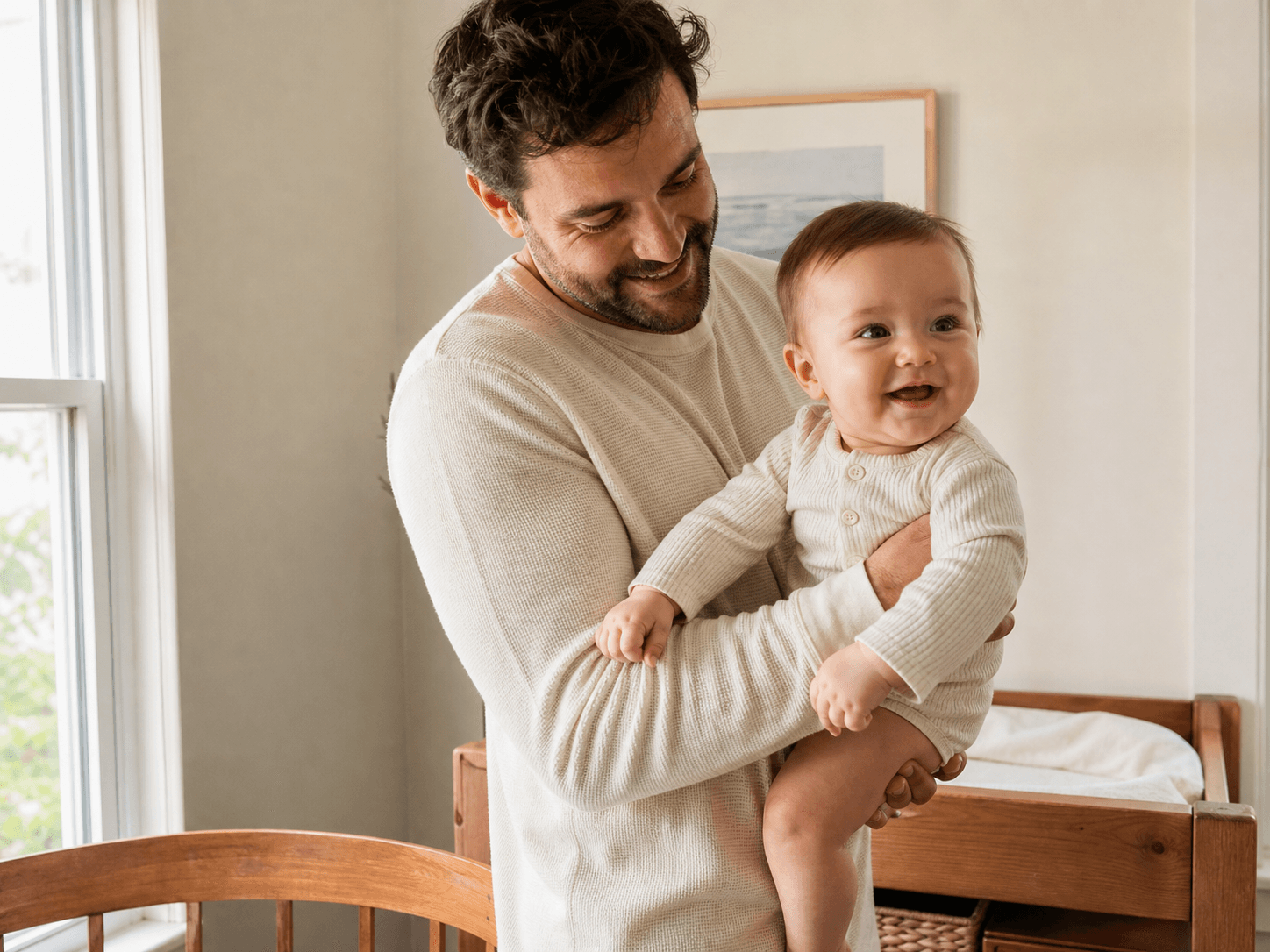 A parent holding a happy baby at home
